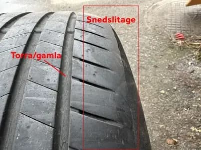 Däck med snedslitage längs ena kanten och torrsprickor i gummit, utmarkerat med röda etiketter